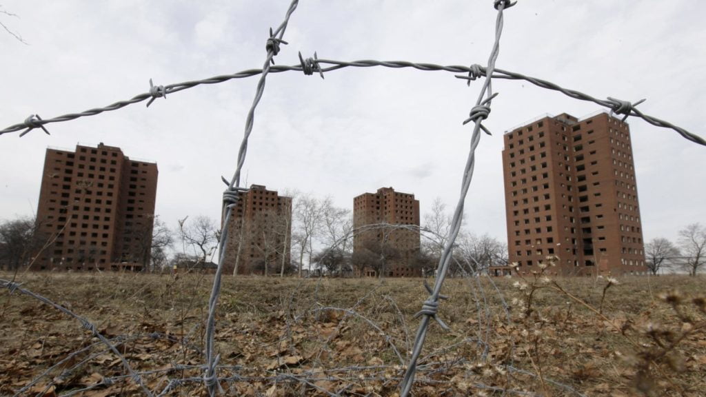 Detroit's Brewster-Douglass towers seen from behind barbed wire. Photo by Paul Sancya-AP